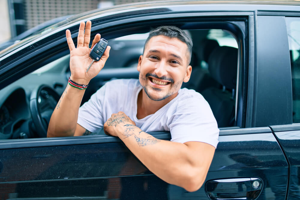 Man leaning out the window with car keys in hand
